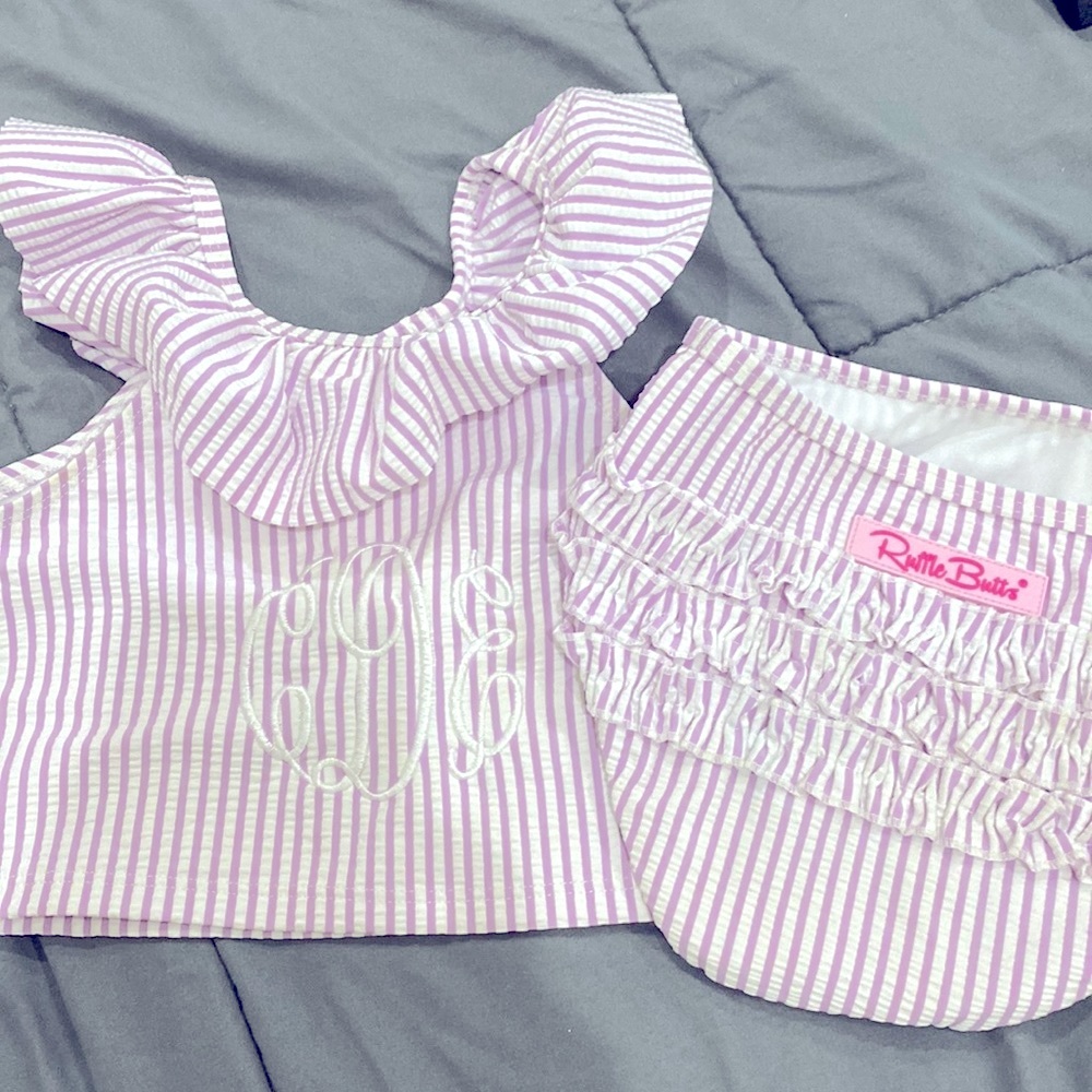 Ruffle Butts 2 piece swim suit. Purple seersucker with monogram “cDe” in white